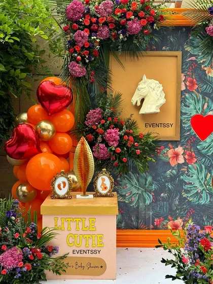 This image highlights the personalized details, including framed sonogram pictures and a custom "Little Cutie" sign. These elements make the celebration deeply personal for the parents-to-be.