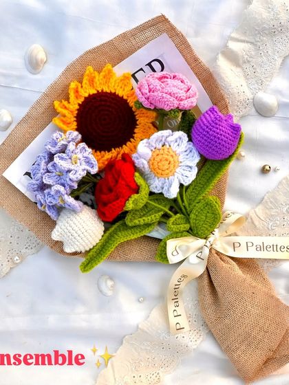 Our 'Ensemble' bouquet is a poem in floral form. This vibrant mix includes a sunflower, rose, tulip, daisy, and forget-me-nots, all wrapped in rustic burlap.