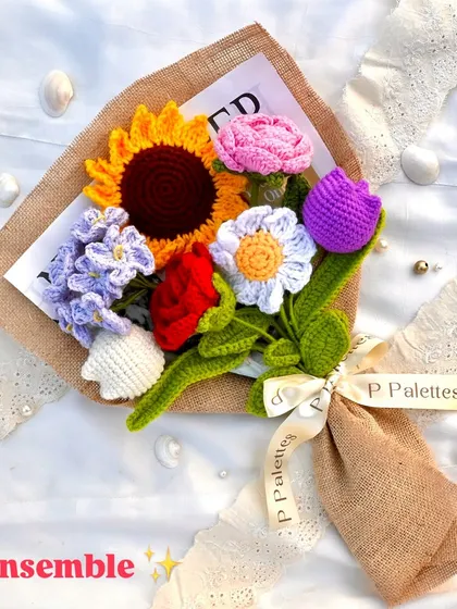 Our 'Ensemble' bouquet is a poem in floral form. This vibrant mix includes a sunflower, rose, tulip, daisy, and forget-me-nots, all wrapped in rustic burlap.
