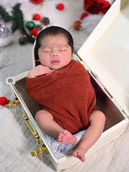Another take on the Christmas gift box theme, this time with the baby wrapped in a warm, earthy red.