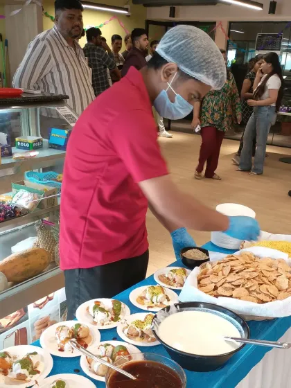 We bring the fun to your event with interactive live food stations. Here, our chef is preparing fresh dahi papdi chaat at a corporate party, allowing guests to customize their snacks just the way they like them. It’s a great way to add energy and engagement to any celebration.