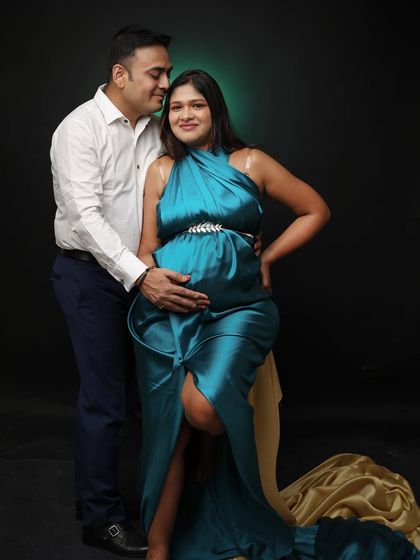 A beautiful portrait of a couple ready to become parents. The mom-to-be, wearing a crown, shares a loving gaze with her partner.
