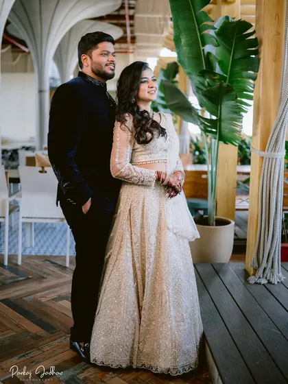 A beautifully composed portrait of Swati and Sarthak. They stand together, looking towards their future, with the lush greenery adding a touch of nature to the indoor setting.