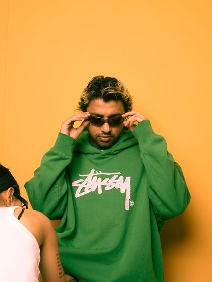 A behind-the-scenes shot from a photoshoot, adjusting my shades.