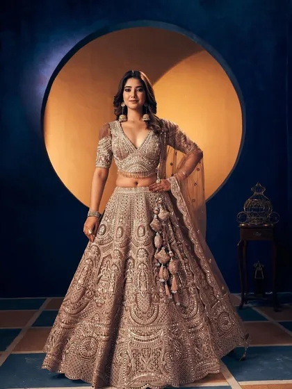 This is for the bride who loves intricate details. A full view of a heavily embroidered champagne gold lehenga, showcasing the craftsmanship that makes my rental collection feel truly high-end and luxurious.