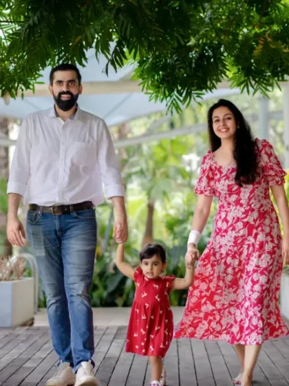 A happy family strolls hand in hand through a lush Bangalore park. We believe the most magical family portraits happen during these natural, unposed moments of togetherness.