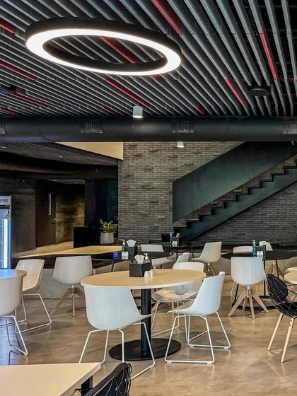 The work lounge at BCG HQ offers different types of seating arrangements, from cafe tables to more relaxed settings, supporting various work styles within a cohesive design.