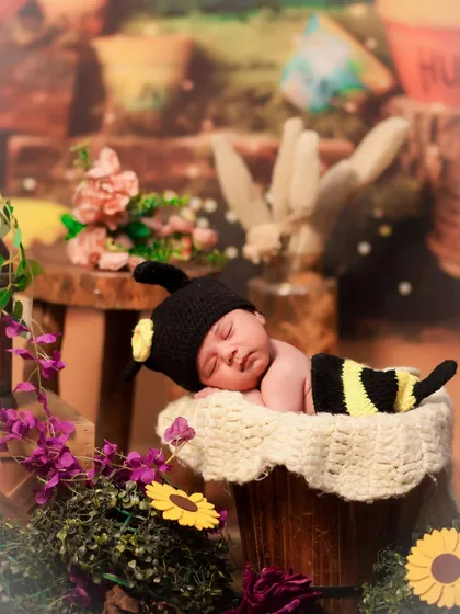 A close-up shot of the sleeping honeybee baby, showing the details of the hand-knitted costume and the peaceful expression.