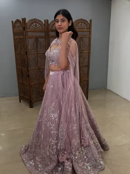 A side view showing the flow of the cape and the intricate silver floral embroidery on the lehenga.