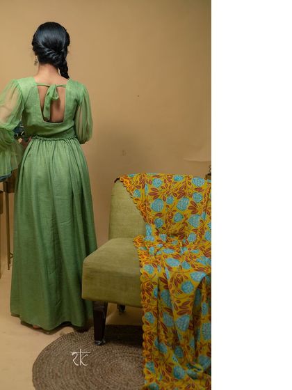 A full back view of the pickle green dress, highlighting its simple elegance and flowing silhouette.