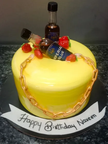 A simple yet fun cake for a party, featuring miniature bottles of Imperial Blue whisky and a gold chain.