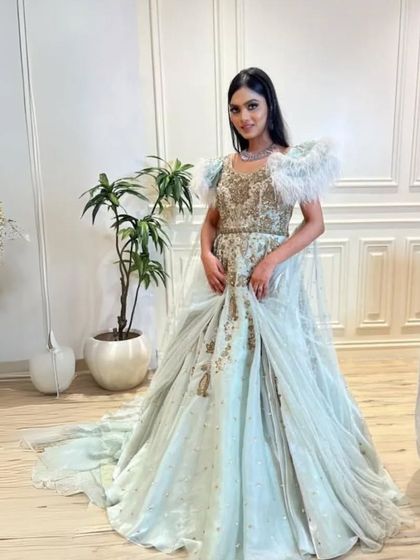 This light blue gown with feathered shoulders is a truly unique and high fashion piece. It is perfect for anyone wanting to make a memorable statement.