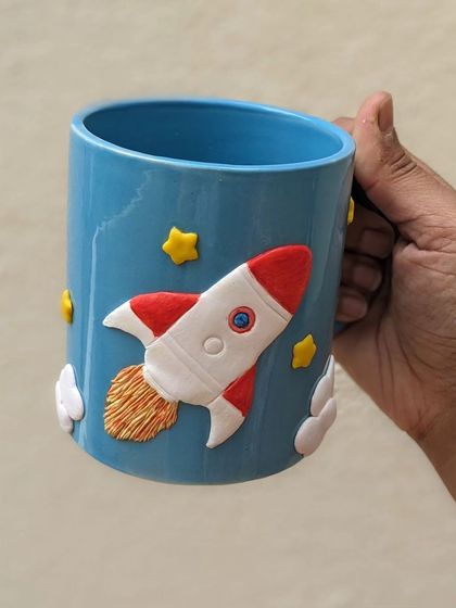 The other side of the space mug, featuring a rocket soaring through the sky. A conversation starter with every sip.