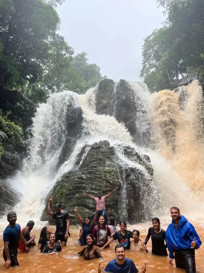 Our group having a fantastic time in the rushing, muddy waters of a monsoon-fed waterfall during our Bandaje trek.