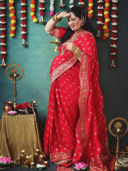 A moment of prayer and gratitude. This expecting mother performs a small ritual, bringing a sense of peace and divinity to her traditional Indian maternity photoshoot.