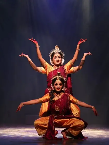 A beautifully synchronized moment from "Shrishti Stithi Laya". The three dancers move as one, their forms highlighted by dramatic spotlights, embodying the principles of creation, preservation, and dissolution.