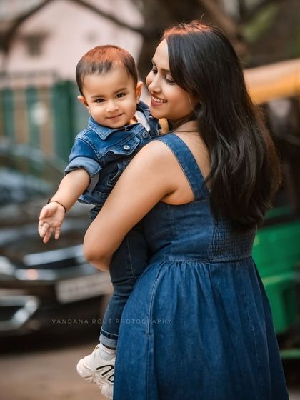 This candid shot captures a mother holding her child on a city street. The natural setting and their relaxed interaction create an authentic and heartwarming urban family portrait.