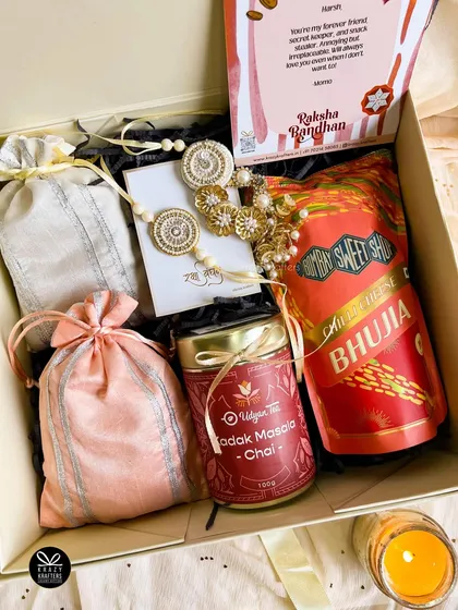 Celebrating the special 'bandhan' of Rakhi with a touch of laad pyaar. This hamper for a bhaiya and bhabhi includes traditional snacks, masala chai, and a beautifully handcrafted couple rakhi set.