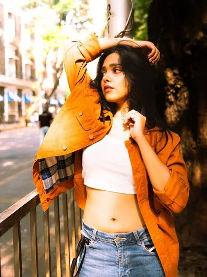 Using the natural light filtering through the trees to create a beautiful, dappled effect. This adds depth and interest to a street-style photo.