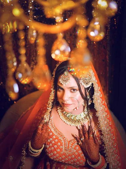 A creative bridal portrait shot through a chandelier, using foreground blur to create a dreamy, magical effect.