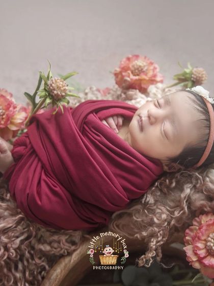 Another view of this sweet baby, showcasing the full wrap and the beautiful floral arrangement that adds a touch of nature to the portrait.