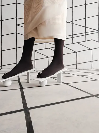Another view of the unique footwear, showing how it creates an illusion of instability and balance.