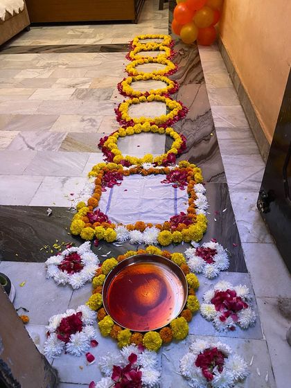 This image provides a complete look at the traditional floral pathway arrangement for the bride's welcome ceremony.