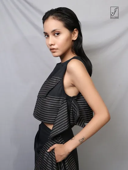 A close-up portrait from the same series, focusing on the model's sharp, direct gaze and the unique texture of the striped top.
