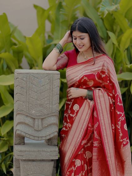 Our client looks stunning in a rich red Banarasi silk saree, a timeless piece that exudes grace and sophistication.