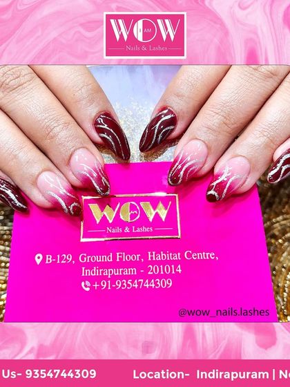 A bold and beautiful ombré on stiletto extensions. This design fades from a deep burgundy to a bright red, with abstract silver lines adding a modern, edgy touch.