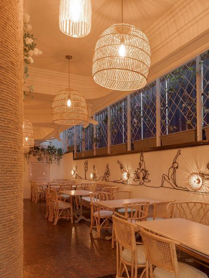 An identical view of the Sante Spa Cafe interior. The line art on the wall and the natural textures of the furniture create a serene and calming atmosphere, fitting for a spa-themed restaurant.