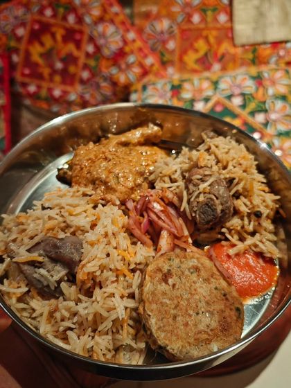 A plate of delicious biryani, served with a side of shami kebab. This is the kind of festive food that brings colour and joy to any celebration. It’s rich, aromatic, and full of flavour.