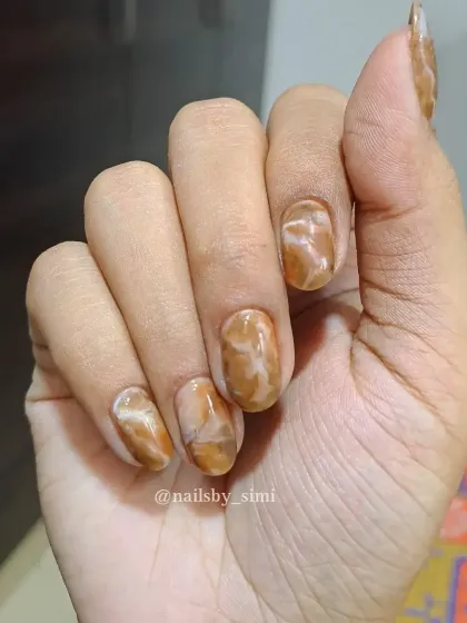 These caramel marble nails are giving cozy vibes. The warm brown and cream tones swirled together create a beautiful and sophisticated pattern.