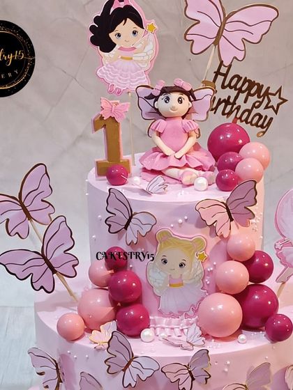 Another angle of the enchanting fairy and butterfly themed cake, highlighting the delicate paper butterflies and fondant girl topper that make this design so special.
