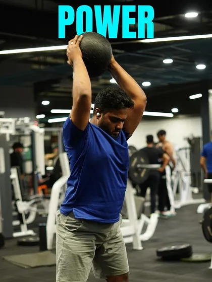 A member executes a powerful medicine ball slam, an explosive movement that builds core strength and cardiovascular endurance.