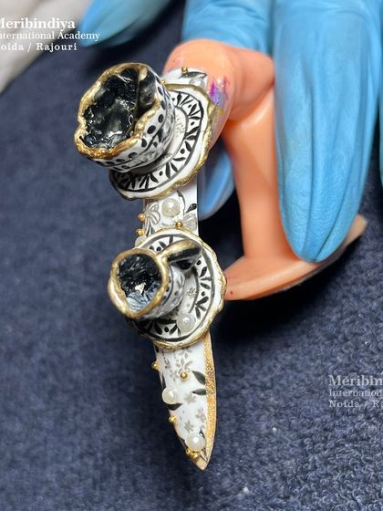 This angle showcases the full composition of the 3D royal teacup nail art, including the pearl embellishments and hand-painted monochrome patterns on the stiletto nail.