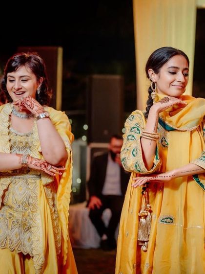 A graceful moment between two performers at the mehendi ceremony.