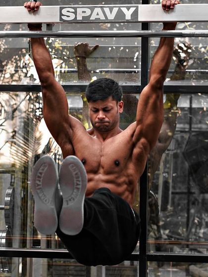 The Mind-Muscle Connection. Performing a hanging leg raise, an advanced core exercise that requires immense control and focus to properly engage the abdominal muscles.