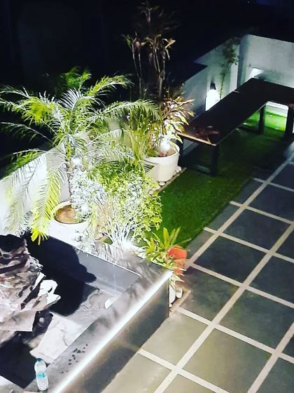 A high-angle view of the terrace landscaping, showing the water feature, planters, and seating bench, all designed to complement the glass room.