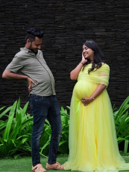 A playful and funny maternity shot where the dad-to-be joins in on the fun. The bright yellow gown adds to the cheerful and lighthearted mood.