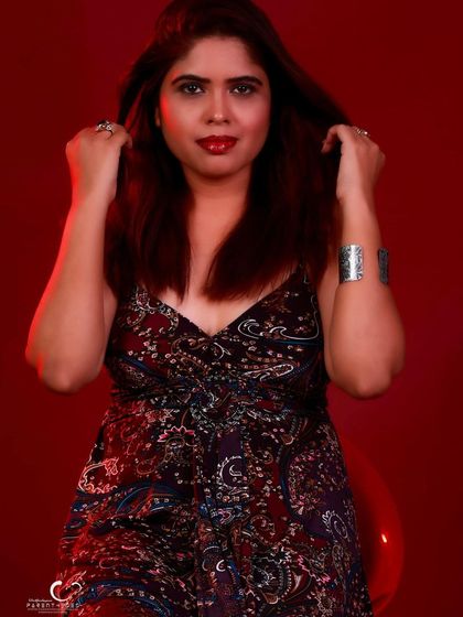 A playful and engaging close-up. The hand in her hair adds a touch of natural movement.