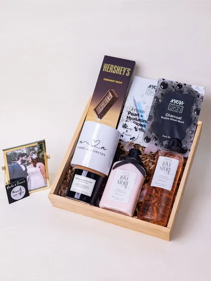 Celebrating the beginning of a forever love story with this elegant hamper for a newlywed couple. It includes 'Love Story' bath products, a personalized mug with the couple's names, a scented candle, and a framed photo to capture their special moment.