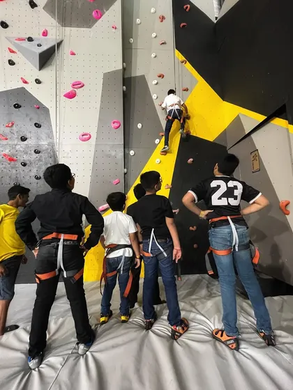 Learning together is a key part of the experience. Here, a group of friends watch and cheer on their buddy, waiting for their turn to try the route. It’s all about teamwork and encouragement.