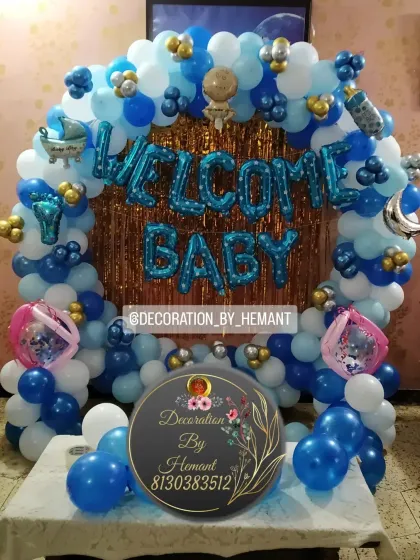 Welcoming a baby boy with a classic blue and white balloon decoration. This arch setup includes a metallic fringe backdrop, "Welcome Baby" foil balloons, and cute baby-themed accents, perfect for photos at home.