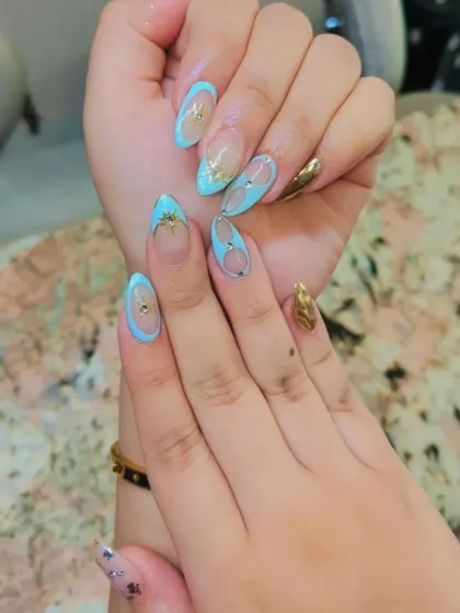 A unique and stylish design featuring a "negative space" look. I used a light blue polish to create outlines and shapes on a clear nail, accented with gold foil.