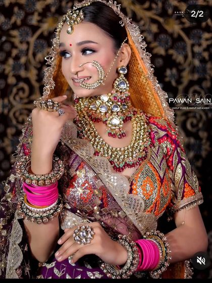 A bride wearing a multi-colored lehenga with a heavy Kundan and Polki set. The pink bangles add a beautiful pop of color to the overall look.