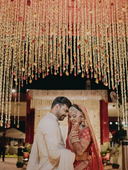 A couple shares an intimate moment under a ceiling of cascading flowers. This photo captures the romantic and dreamy atmosphere I strive to create for every wedding.