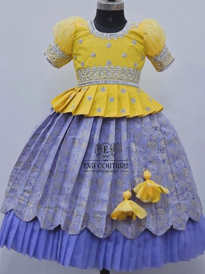 A soft and elegant lehenga in yellow and lavender. The layered skirt and pleated peplum blouse create a beautiful silhouette.