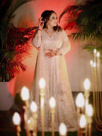 Another beautiful shot of the bride, Pooja, framed by glowing lights at her engagement.