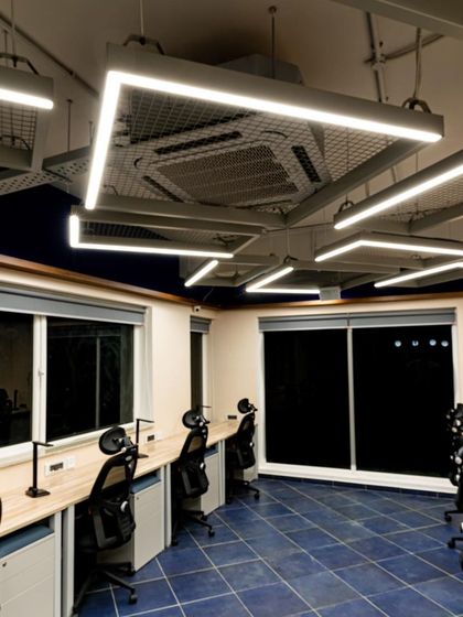 This view shows how the geometric light fixtures create a cohesive and dynamic ceiling-scape. The design ensures that every workstation receives consistent, high-quality illumination, promoting focus and well-being.